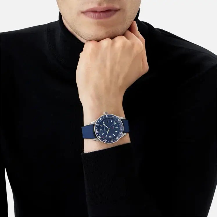 Montblanc 1858 GMT Automatic ref: 129617 herenhorloge 42mm met blauwe wijzerplaat en rubberen band, gedragen om de pols van een man in zwarte kleding.